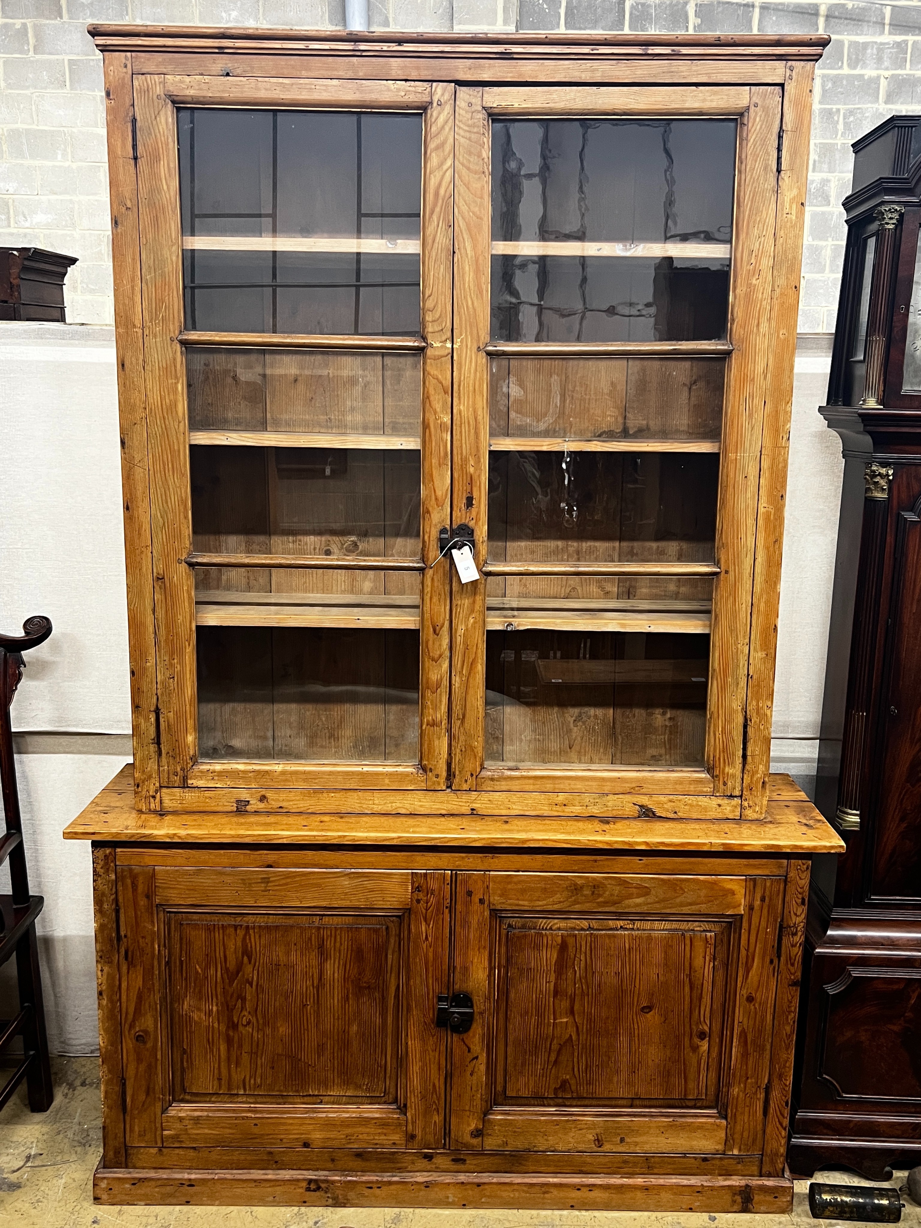 A 19th century French provincial pine two door glazed bookcase, length 151cm, depth 39cm, height 229cm
